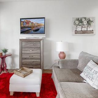 Cozy living room with a comfy sofa, red rug, and stylish decor.