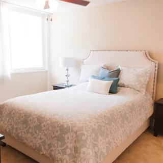 A cozy bedroom with a neatly made bed and soft lighting.
