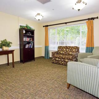 A cozy living room with comfortable seating and a bookshelf by the window.