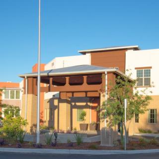 A modern building with landscaping under a clear blue sky.