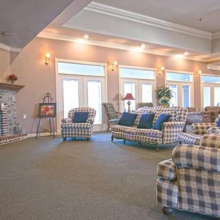 A spacious living room with plaid upholstered furniture and large windows.