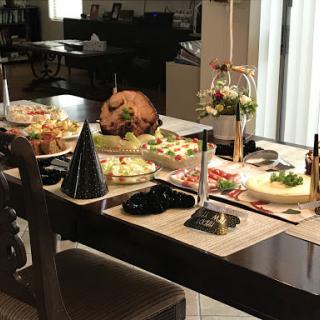 A beautifully set dining table featuring an assortment of festive dishes, including a roasted turkey and colorful salads, perfect for a celebration.