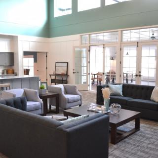 A spacious living room with modern furniture and large windows.