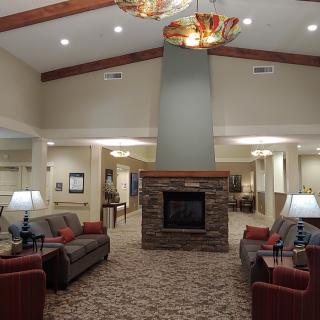 Spacious lobby featuring comfortable seating and a central fireplace.