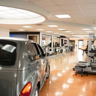 A modern showroom interior featuring a car and various display setups.