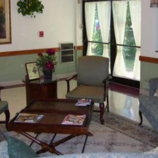 A cozy waiting area with comfortable chairs and a table adorned with magazines and decorative plants.