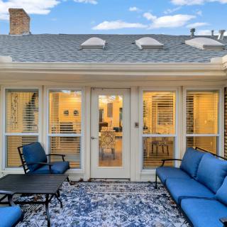A cozy outdoor patio with blue cushioned seating and a glass door leading inside.