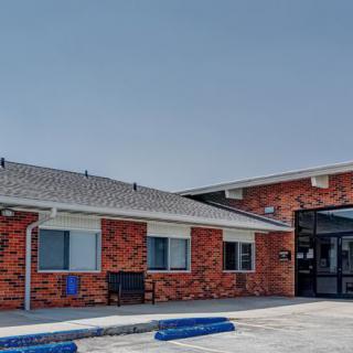 A brick building with large windows and a main entrance.