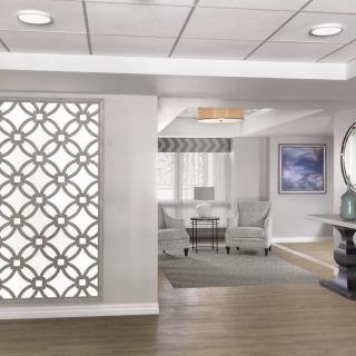 A modern lobby interior with a decorative wall, seating area, and neutral color palette.