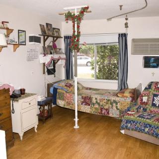A cozy interior space with a bed, decorative quilts, and a view through the window.