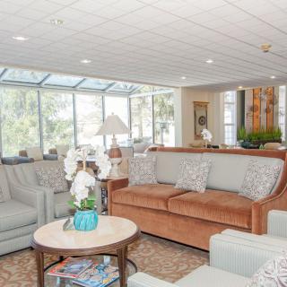 A bright and spacious living room featuring comfortable sofas, a coffee table, and large windows allowing natural light to fill the space.