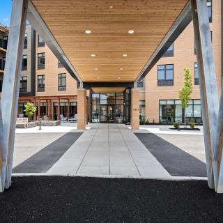 A modern building entrance with a covered walkway and contemporary design elements.