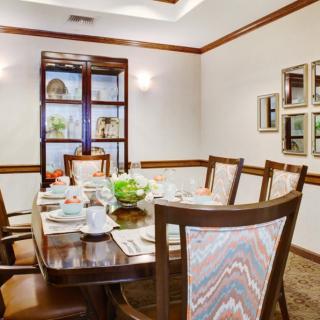 An elegant dining room with a set table and plush chairs.
