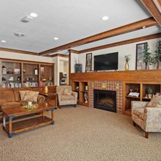 A cozy living room featuring a fireplace, television, and comfortable seating with wooden accents.