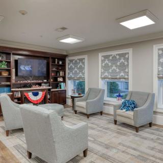 A cozy living room with armchairs, a TV, and decorative accents.