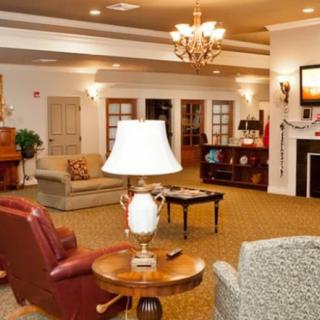 A cozy living room with comfortable seating, elegant lighting, and a warm fireplace.