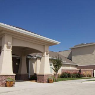 A modern building with a prominent entrance under a clear blue sky.