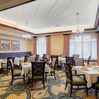 An elegant indoor dining room setup with neatly arranged tables and chairs.