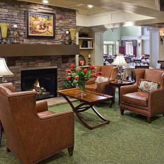 A cozy living room with a fireplace, leather chairs, and warm decor.