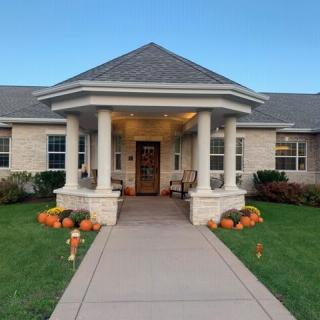 A cozy house with a welcoming porch decorated with pumpkins for autumn.