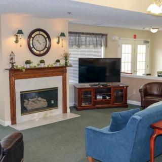 A cozy living room featuring a fireplace, television, and comfortable seating.