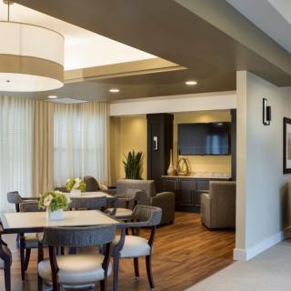 A modern open-concept dining and living area with stylish furniture and neutral tones.