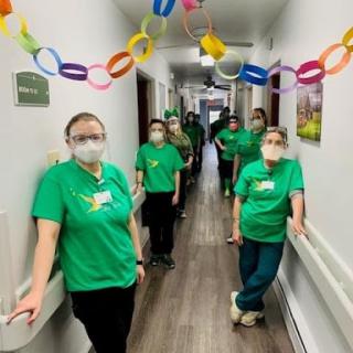 Healthcare staff posing in a decorated hallway.