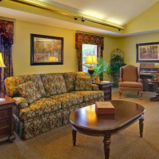 A cozy living room featuring a patterned sofa, elegant decor, and warm lighting.