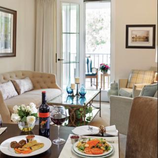A cozy living room with a dining setup, featuring plated meals and wine.