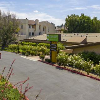 A landscaped entrance to a motel with clear signage and surrounding greenery.
