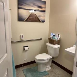 A well-organized bathroom with artwork and essentials neatly arranged.