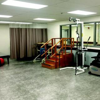A physical therapy facility equipped with exercise equipment and rehabilitation tools.