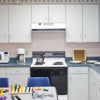 A classroom-style kitchen setup with appliances and toys on the table.