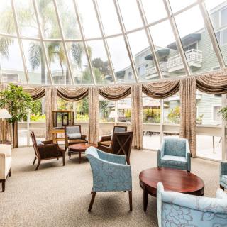 A spacious lobby seating area with elegant furniture and a glass ceiling that lets in natural light.