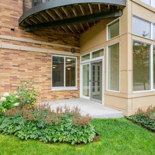 A modern building entrance with large windows and well-maintained landscaping.