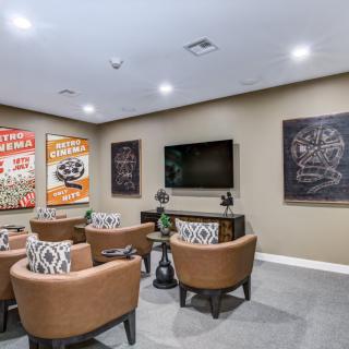 A cozy home theater room with comfortable seating and decorative posters on the walls.