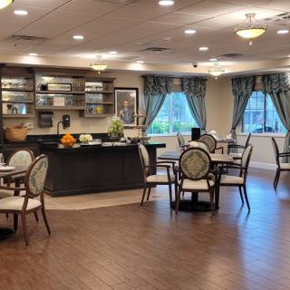 A cozy dining area with neatly arranged tables and chairs, adorned with elegant curtains.