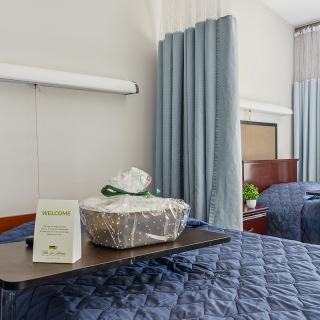 A hospital room with a bed and tray service.