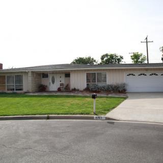 A single-story suburban house with a well-maintained lawn and a two-car garage.