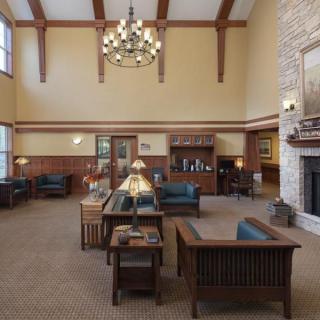 A spacious lobby with comfortable seating, a chandelier, and a fireplace.