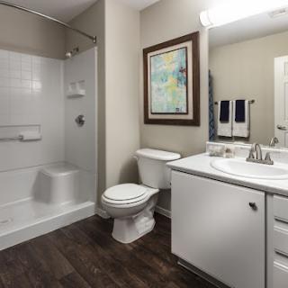 A clean and modern bathroom featuring a shower, toilet, and vanity.