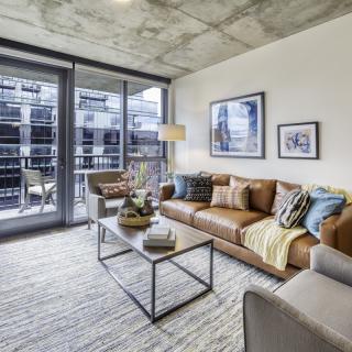 A modern living room with a cozy sofa and large windows letting in natural light.