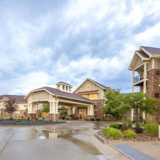A residential complex with neatly maintained gardens and a cloudy sky overhead.
