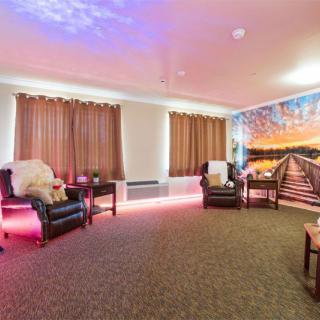 Cozy lounge area with comfortable seating and vibrant mural.