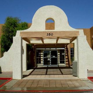 A southwestern-style building entrance with an archway and glass doors.