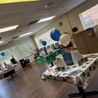 An inviting office space decorated for a celebration with balloons and festive tables.