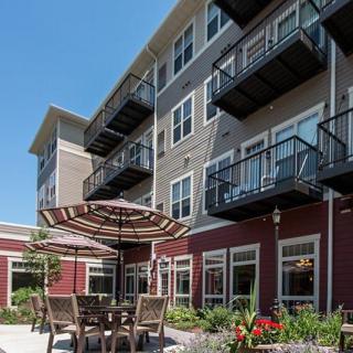 Modern apartment building with balconies and an outdoor seating area.