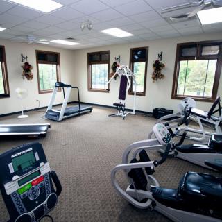 A small gym with various exercise equipment including treadmills and stationary bikes.