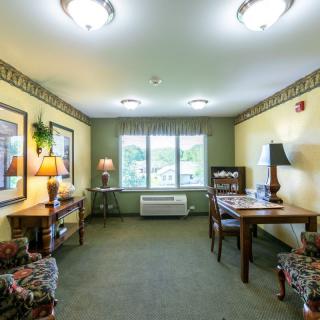 A cozy living room with comfortable seating, tables, and decorative lamps.