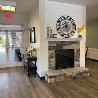 A welcoming entryway with a stone fireplace and decorative clock.